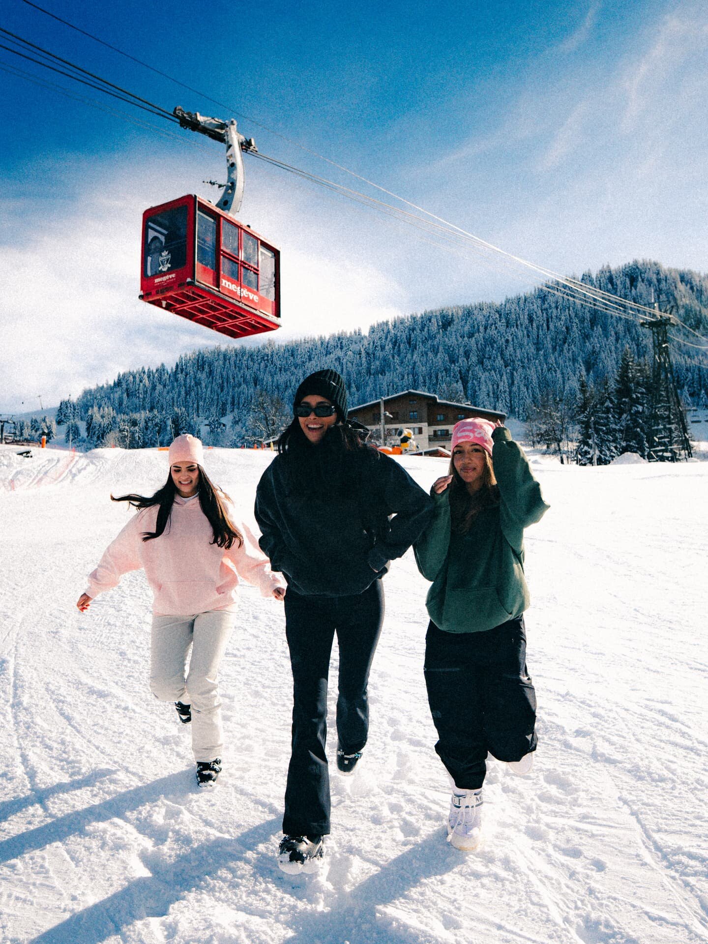 Trois femmes dans la neige sous une télécabine à Megève
